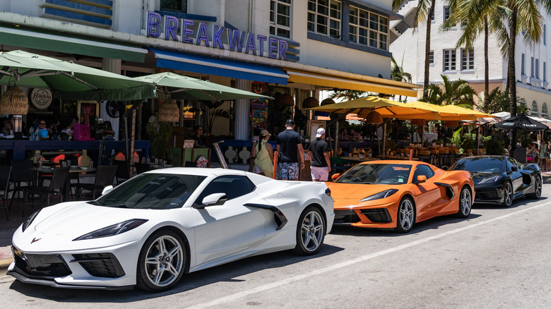 White, orange, and black C8 Corvettes parked outside in Miami