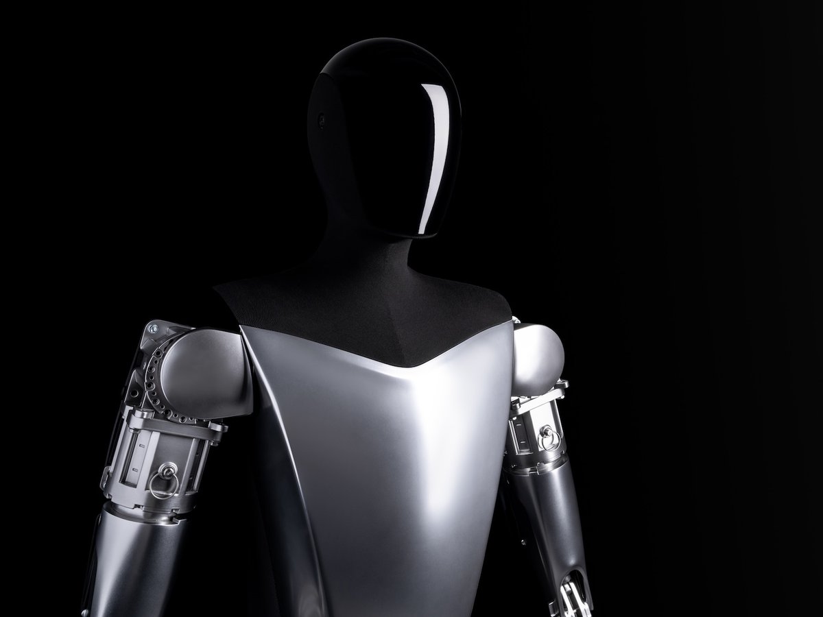 A robot in front a of a black background.