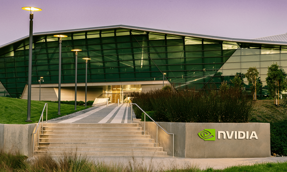 Nvidia headquarters at dusk with a gray sign in front bearing the Nvidia logo.