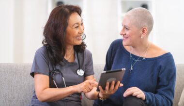 Medical professional consults with patient while sitting on a couch.