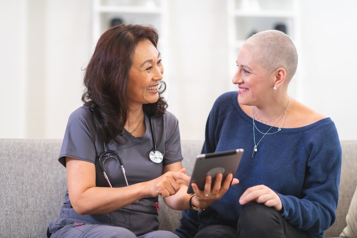 Medical professional consults with patient while sitting on a couch.