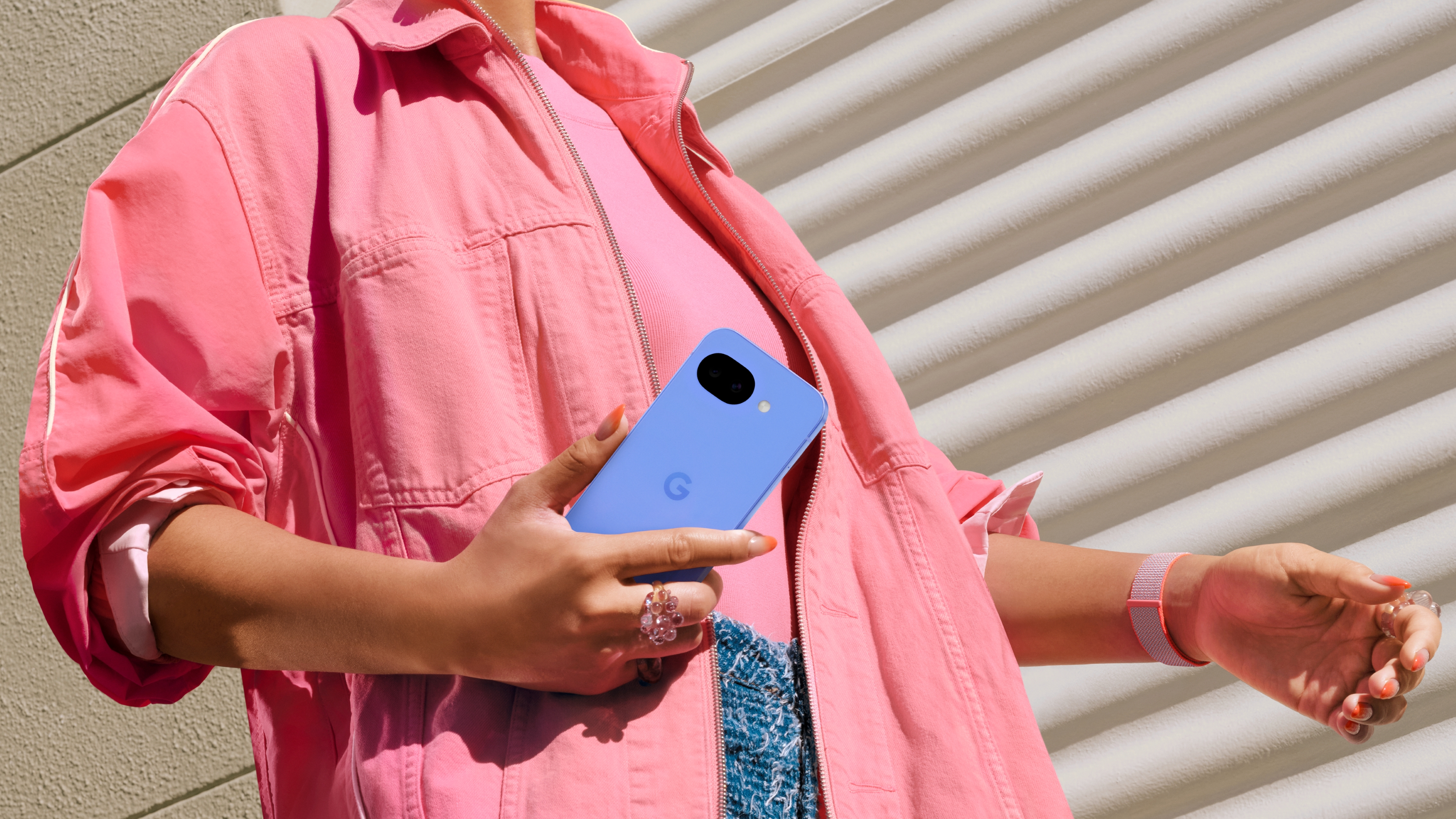 A woman holding the Google Pixel 10a.