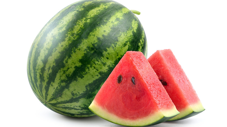 A whole watermelon next to watermelon slices