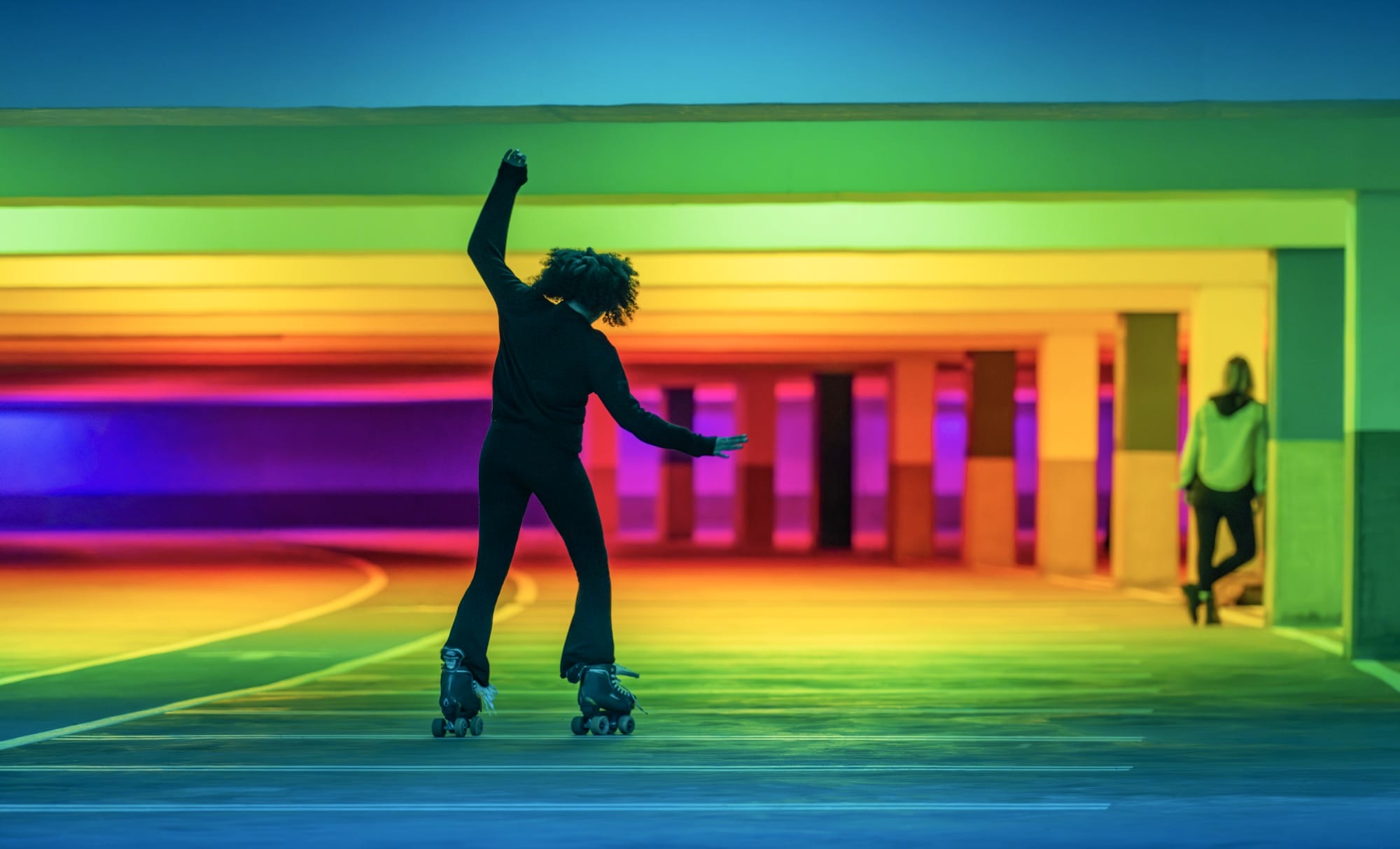 a person roller skates amid chromatic light blanketing a parking garage by Liz West