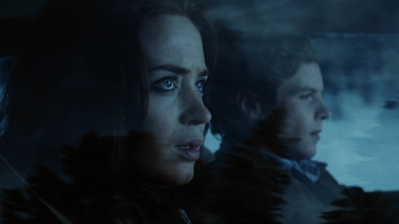 Emily Blunt's Girl looks out of the window as she rides in a car with Ashton Holmes' Guy in Wind Chill