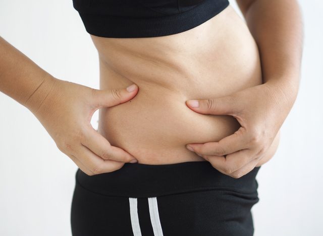 Woman holding hip fat muffin top