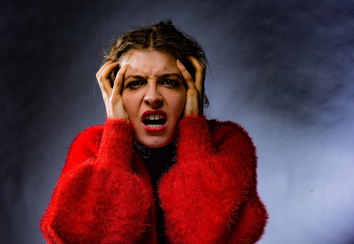 Woman goes berserk, frustrated and angry, holding her head while reacting to brother meddling with her parenting. Woman goes berserk, frustrated and angry, holding her head while reacting to brother meddling with her parenting.