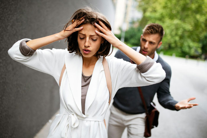 Stressed woman frustrated with brother meddling in her parenting during a tense outdoor argument. Stressed woman frustrated with brother meddling in her parenting during a tense outdoor argument.