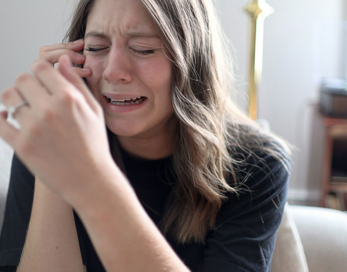 Woman crying and upset indoors, expressing distress related to parenting and family conflict involving her brother. Woman crying and upset indoors, expressing distress related to parenting and family conflict involving her brother.