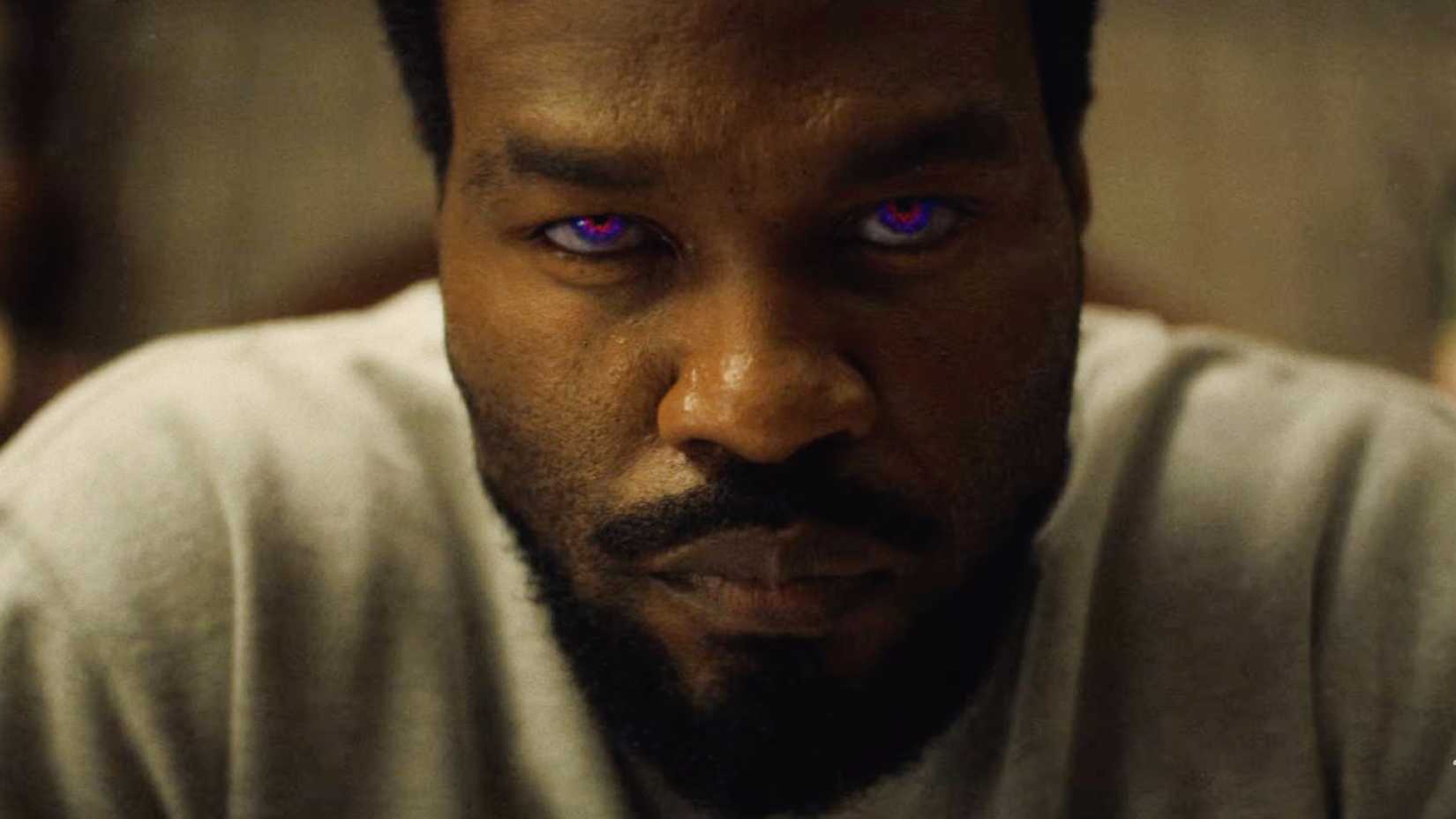 Yahya Abdul-Mateen II starring intensely forward with colored eyes in Wonder Man