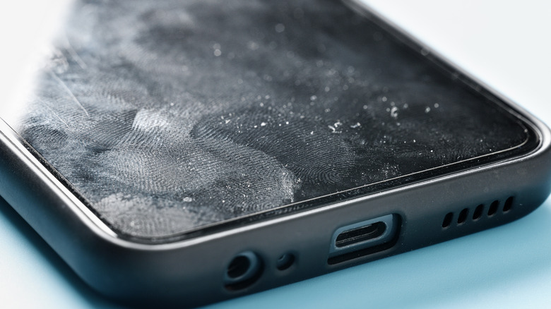 Smartphone screen with fingerprint marks and dust