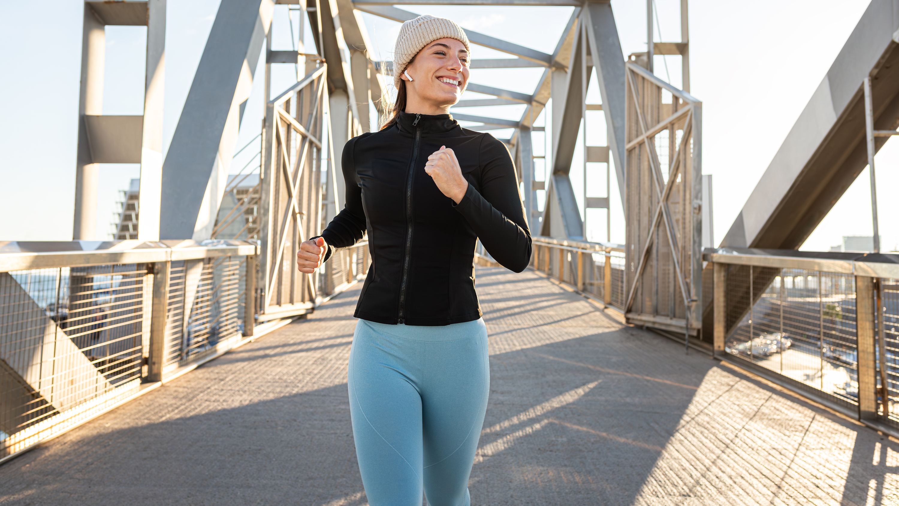 a woman running across a bridge