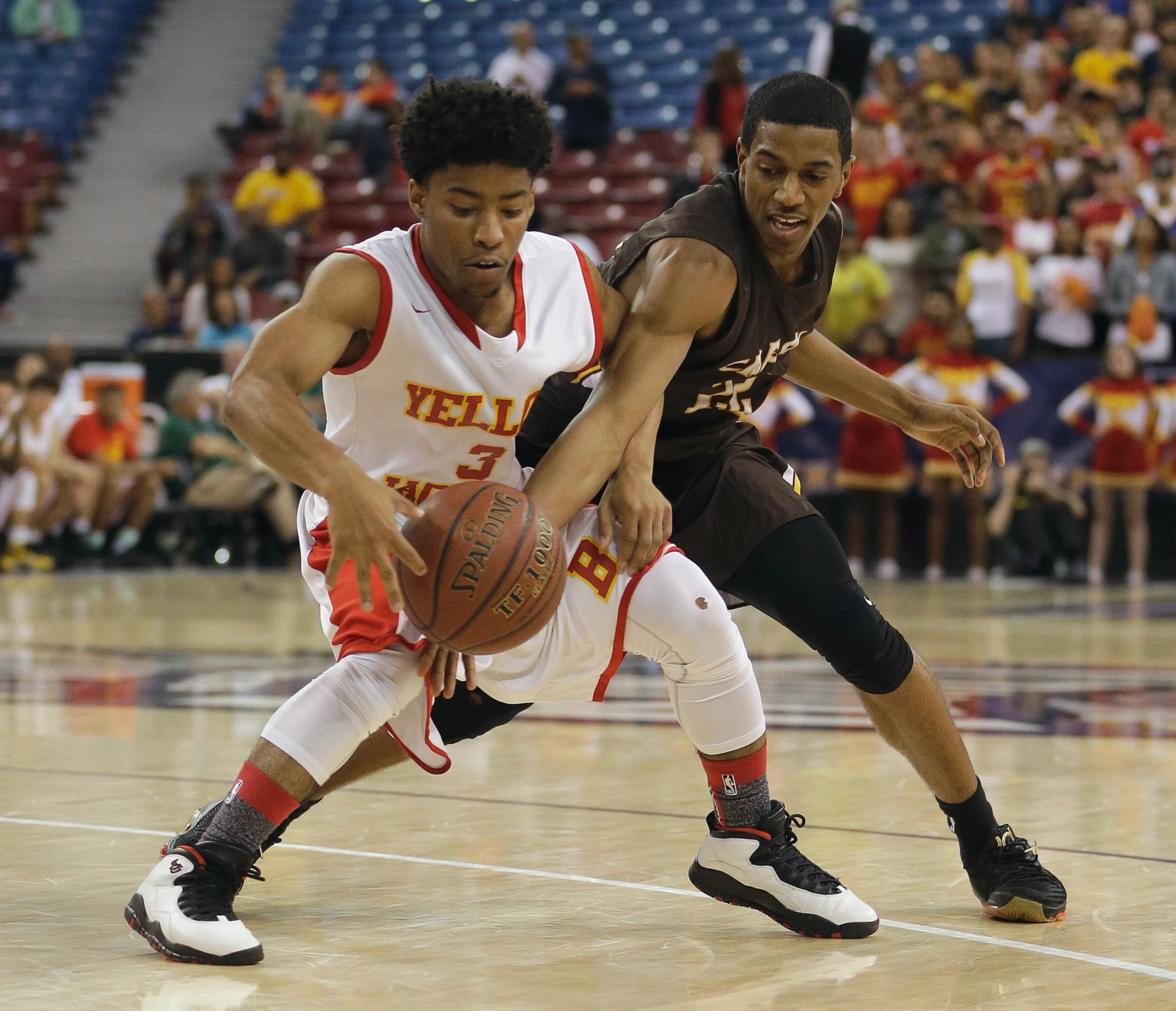 Two basketball players, one in a white and red jersey and the other in a black jersey, are competing intensely for control of the basketball.