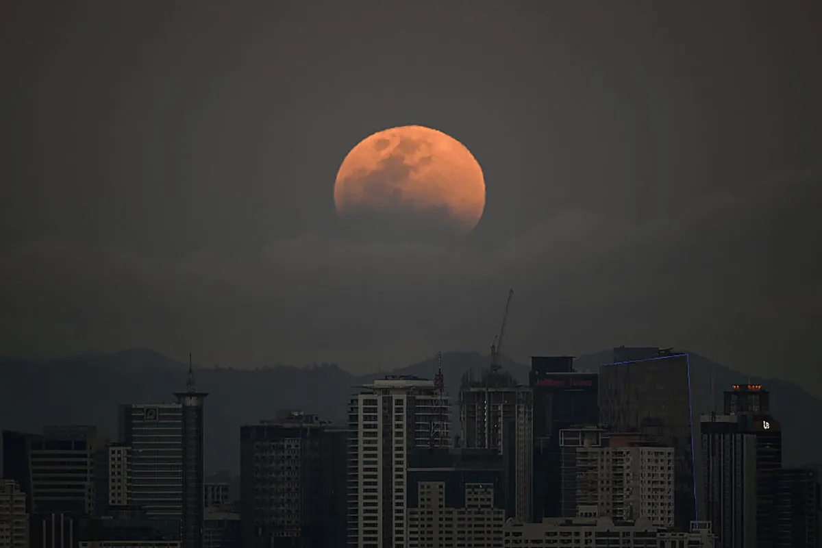 The blood Moon of March 2026 over buildings in Manila in the Philippines. Photo by Ted ALJIBE / AFP via Getty Images