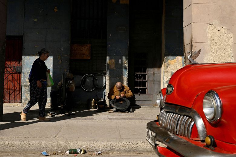 Lorenzo Cortijo repairs a bicycle tire on the sidewalk in Havana on February 24.