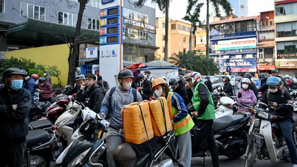 Motorists queue to pump gasoline into their vehicle and oil containers at a gas station in Hanoi, Vietnam, on March 10, 2026. - Nhac Nguyen/AFP/Getty Images