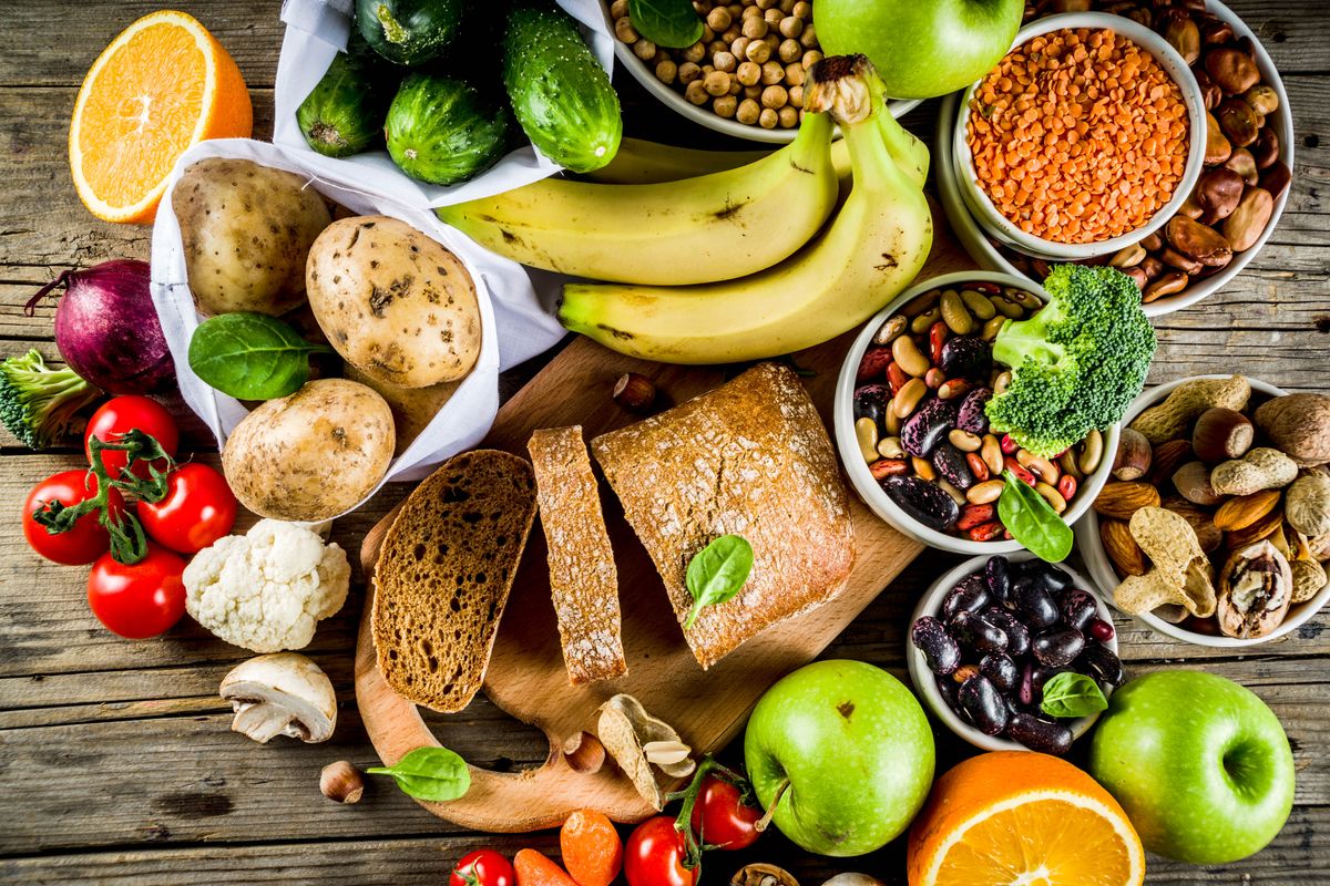 Healthy food. Selection of good carbohydrate sources, high fibre rich food. Low glycemic index diet. Fresh vegetables, fruits, cereals, legumes, nuts, greens. Wooden background copy space