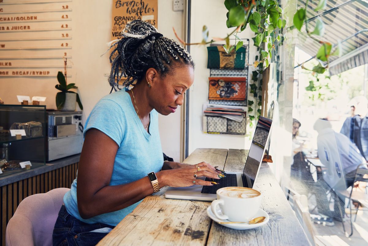 Woman working on a coffee shop using a laptop