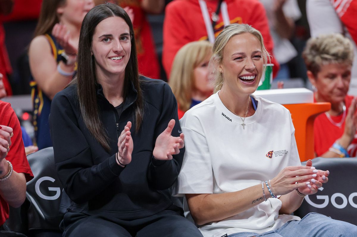 Caitlin Clark and Sophie Cunningham sit on the bench