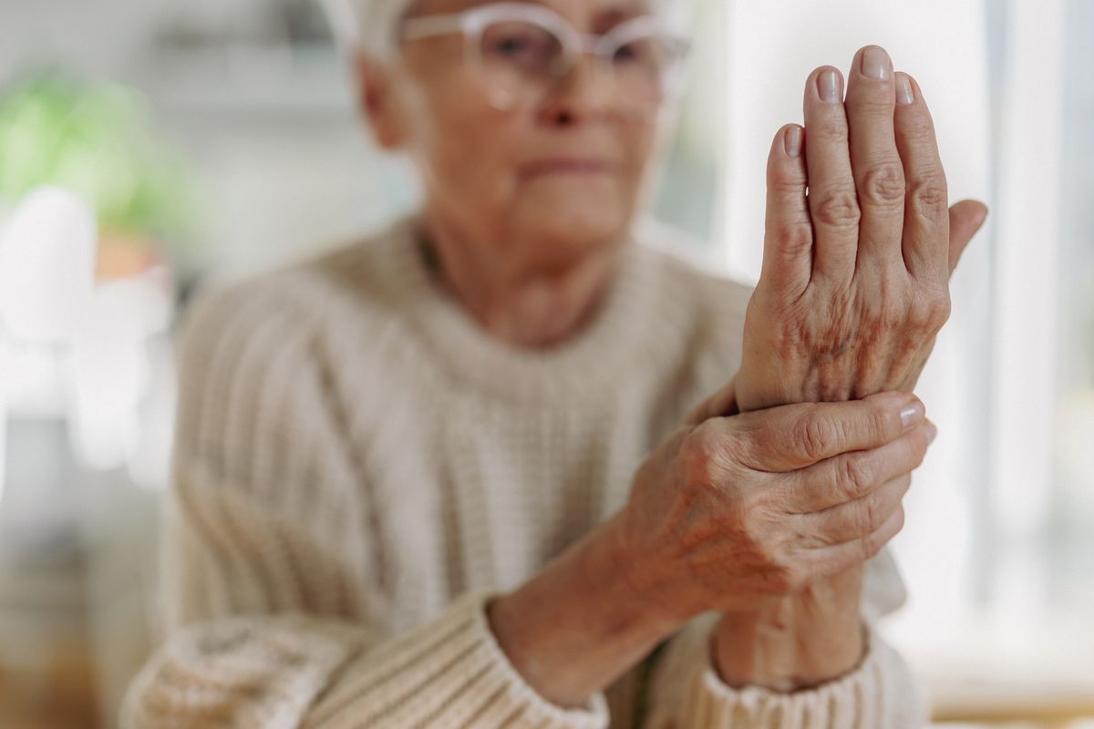 Senior woman with arthritis rubbing hands