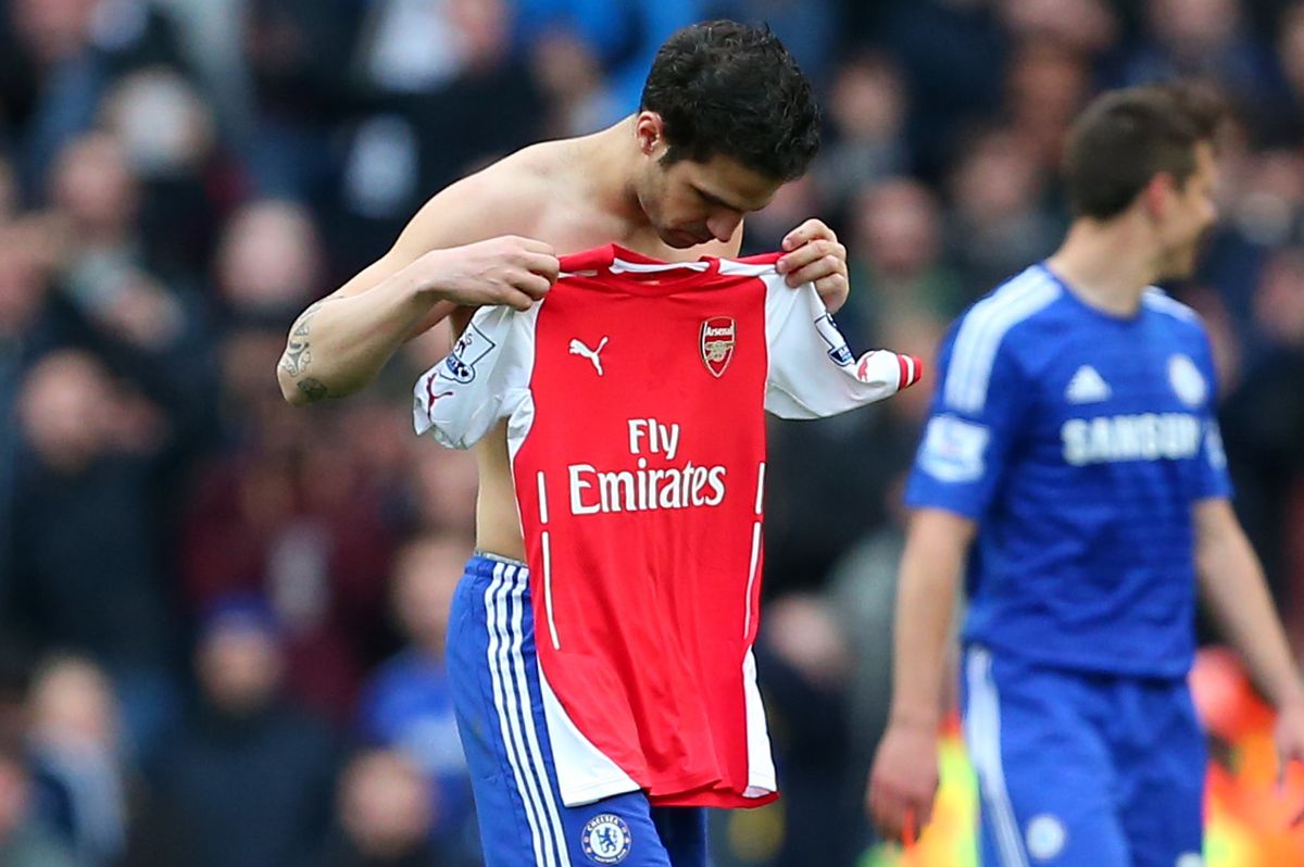 Cesc Fabregas of Chelsea holds the Arsenal shirt of Mesut Ozil up against his chest after they swap shirts at the end of the match.