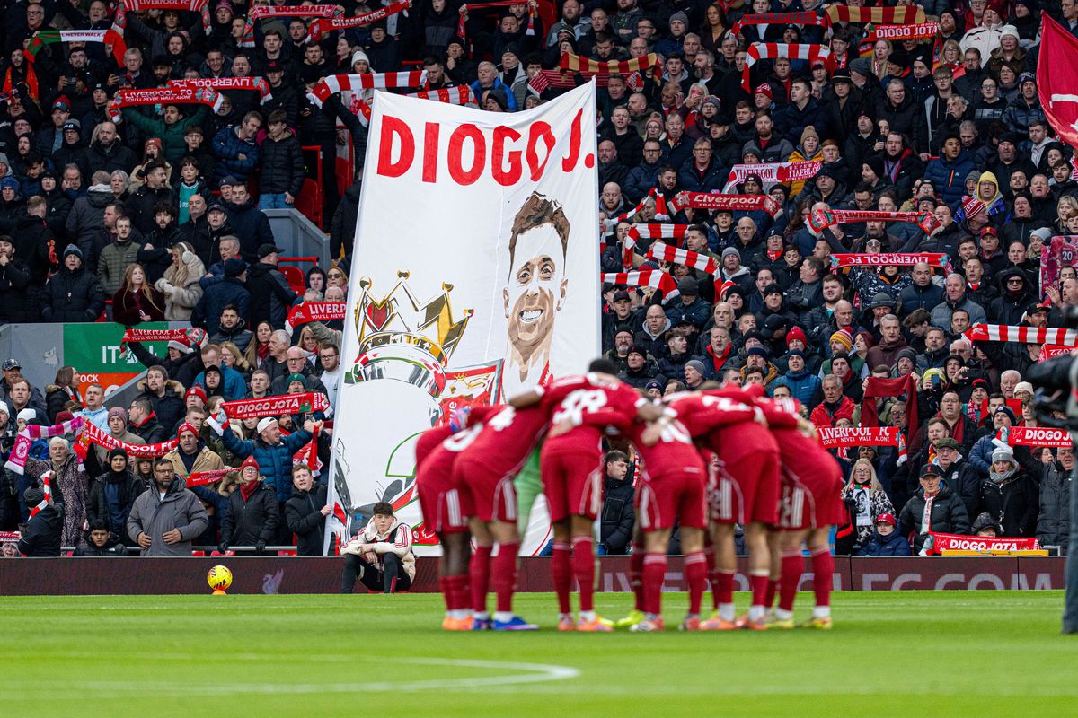 Liverpool's players huddle in front of a banner bearing a tribute to Diogo Jota during the Premier League match between Liverpool and Wolverhampton Wanderers