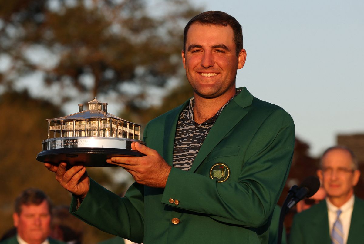 Scottie Scheffler celebrates with his green jacket and trophy after winning The Masters