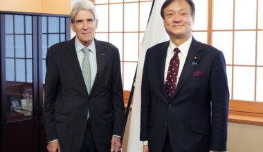 State Minister HORII and Chancellor Frenk standing side by side in front of the Japanese national flag