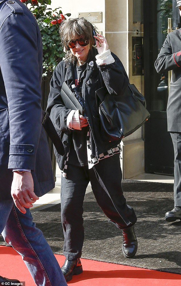 Winona Ryder flashed a smile as she donned a pair of headphones while departing her hotel