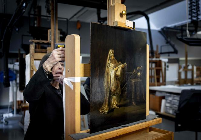 A researcher stands in front of the newly discovered work of Dutch painter Rembrandt van Rijn titled as 