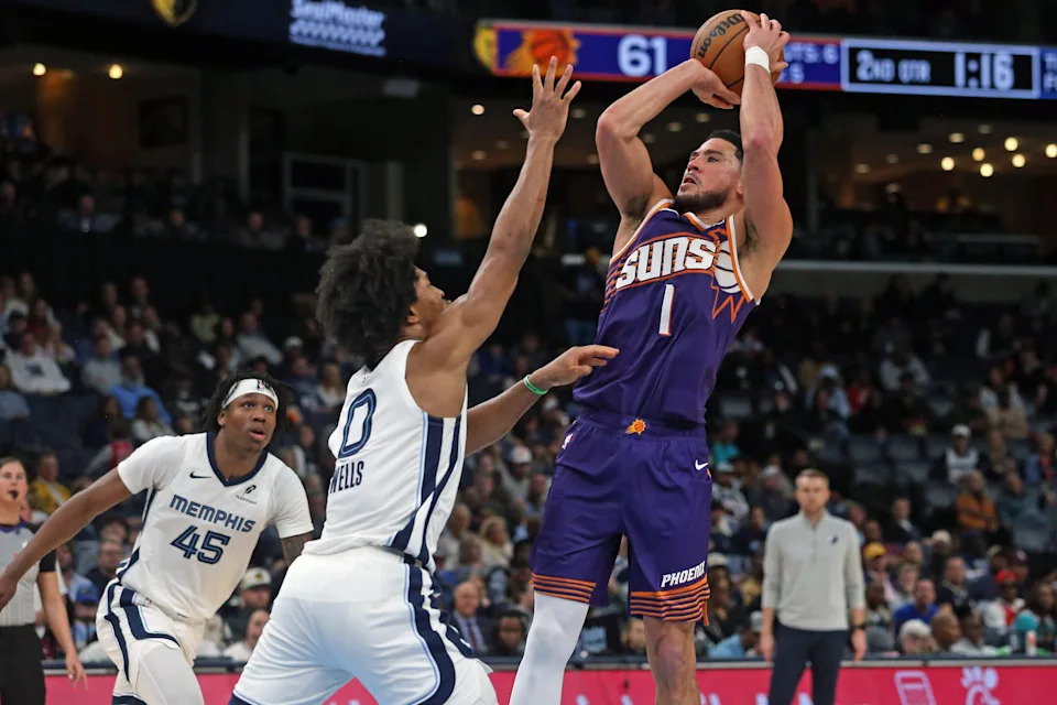 Phoenix Suns guard Devin Booker (1) shoots as Memphis Grizzlies forward Jaylen Wells (0) defends during the second quarter at FedExForum in Memphis, on Jan. 7, 2026.