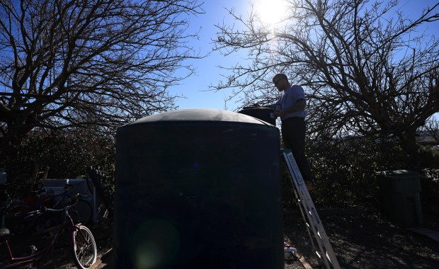 Joe Hulbert checks the water level in a county supplied water tank, Wednesday, Feb. 4, 2026, as part of mitigation efforts after Hulbert's and other rural families were affected by a sewage which contaminated their drinking wells in Clearlake. (Kent Porter / The Press Democrat)