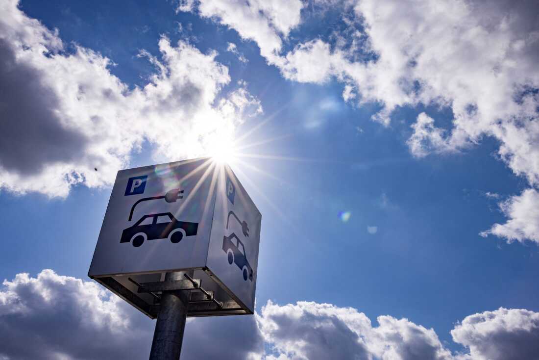 A sign offers parking and charging facilities for electric cars at a retail park in Berlin in 2023. Evidence from the oldest generation of electric vehicles suggests their batteries are lasting longer than was expected in the early days of the EV industry.