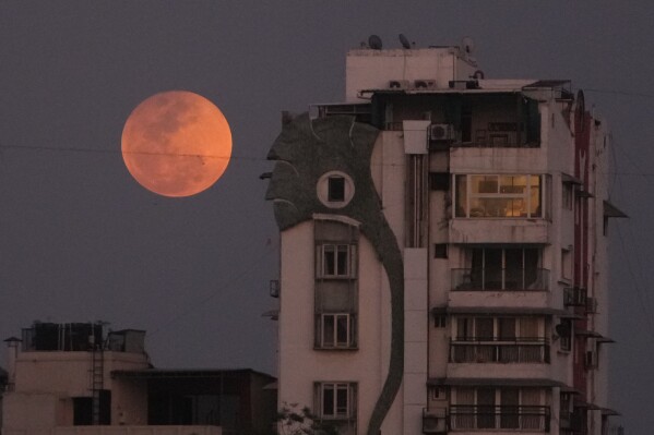 A blood moon rises over Ahmedabad, India, Tuesday, March 3, 2026. (AP Photo/Ajit Solanki)