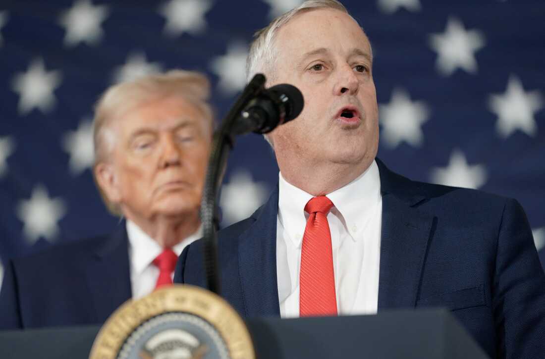 President Donald Trump listens as Michael Whatley, former Republican National Committee Chairman speaks during a visit to the Fort Bragg U.S. Army base on February 13, 2026 in Fort Bragg, North Carolina.