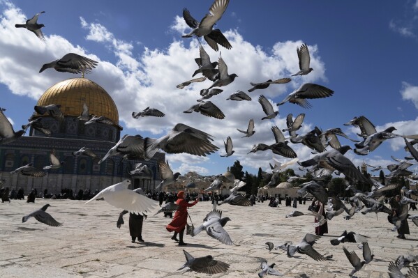 Pigeons fly overhead as worshippers arrive at the Al-Aqsa Mosque compound for Friday prayers in Jerusalem's Old City, Friday, Feb. 27, 2026. (AP Photo/Mahmoud Illean)