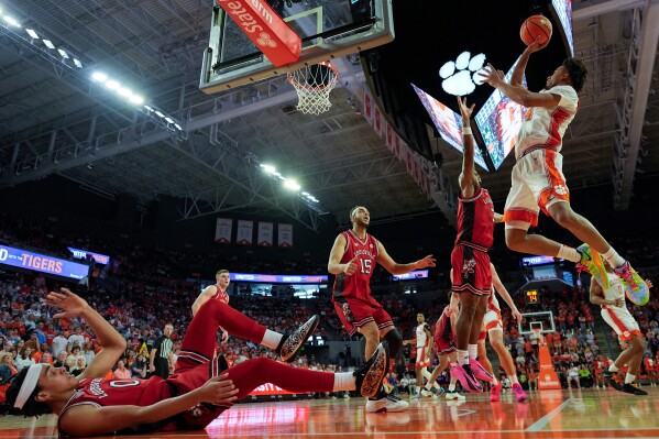 Clemson guard Efrem Johnson (4) shoots against Louisville guard Mikel Brown Jr. (0) during the second half of an NCAA basketball game, Saturday, Feb. 28, 2026, in Clemson, S.C. (AP Photo/Mike Stewart)