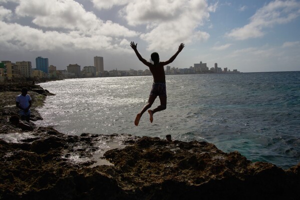 A youth jumps into the sea during a blackout in Havana, Wednesday, March 4, 2026. (AP Photo/Ramon Espinosa)