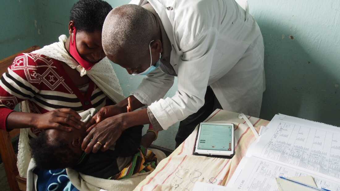 The photo is of a child (held by his mother) who was treated with the ePOCT+ algorithm in a health center in Rusizi district, Rwanda. The photo was taken by Magali Rochat in May 2023.