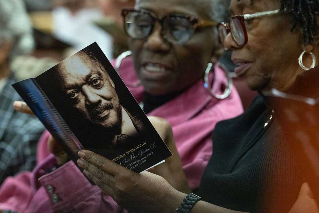 People attending a celebration of life service for civil rights leader Rev. Jesse Jackson hold a program with his image on the cover.