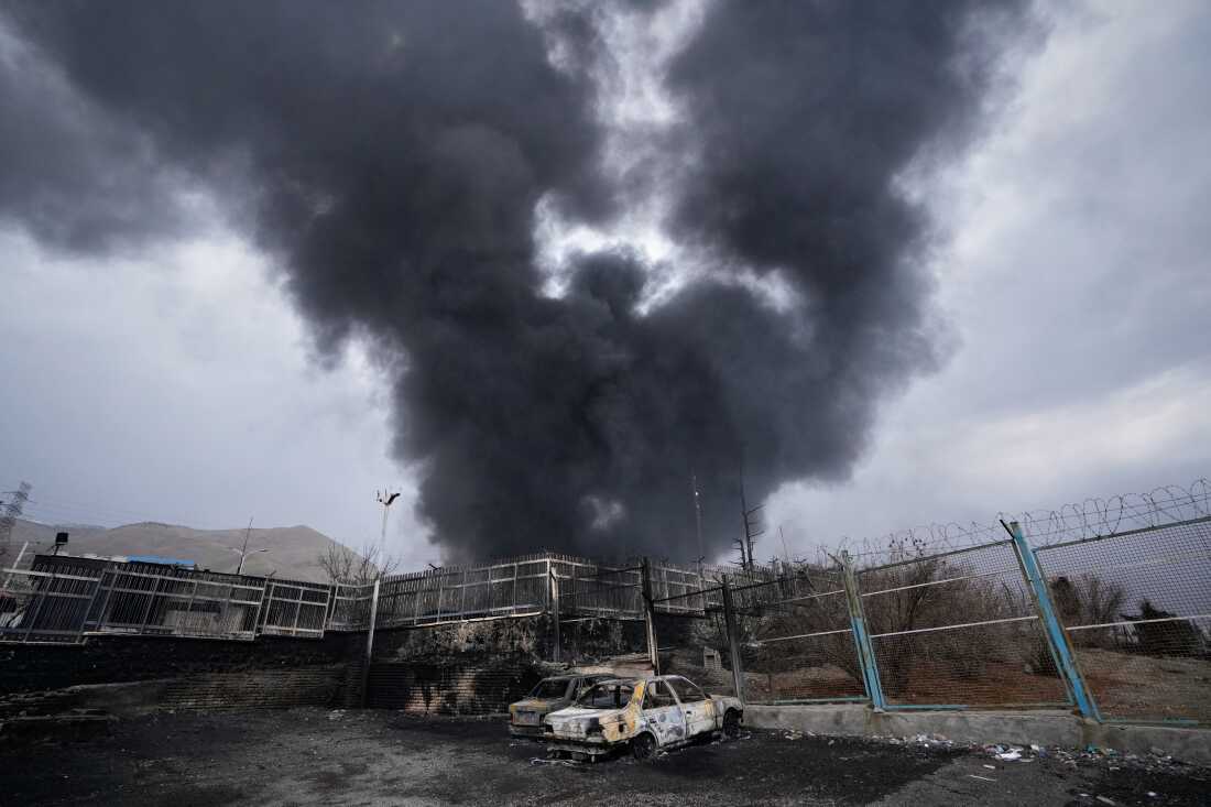 A thick plume of smoke rises from an oil storage facility hit by a U.S.-Israeli strike in Tehran, Iran.