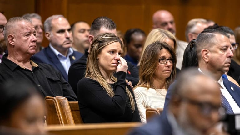 Stephanie Diller, center, the widow of NYPD Det. Jonathan Diller,...