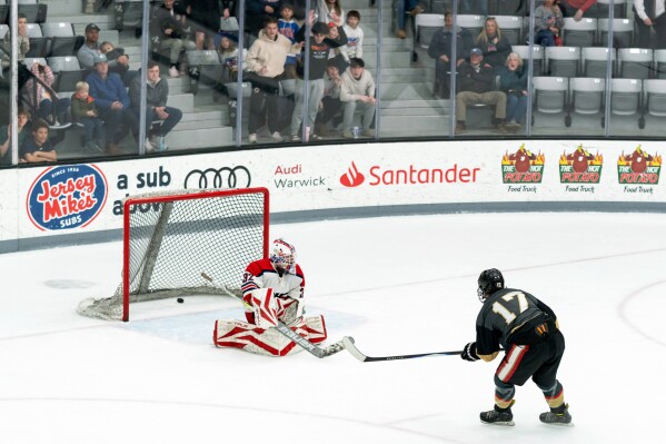 Blackstone Valley Schools forward Colin Dorgan shoots the puck past the goaltender to score the double-overtime game-winning goal against Portsmouth High School in the Rhode Island high school hockey state semifinal Wednesday, March 11, 2026, at Schneider Arena in Providence, R.I. (Courtesy of T.J. Auclair & Kyle Auclair/Little Big Leaguers Photography via AP)