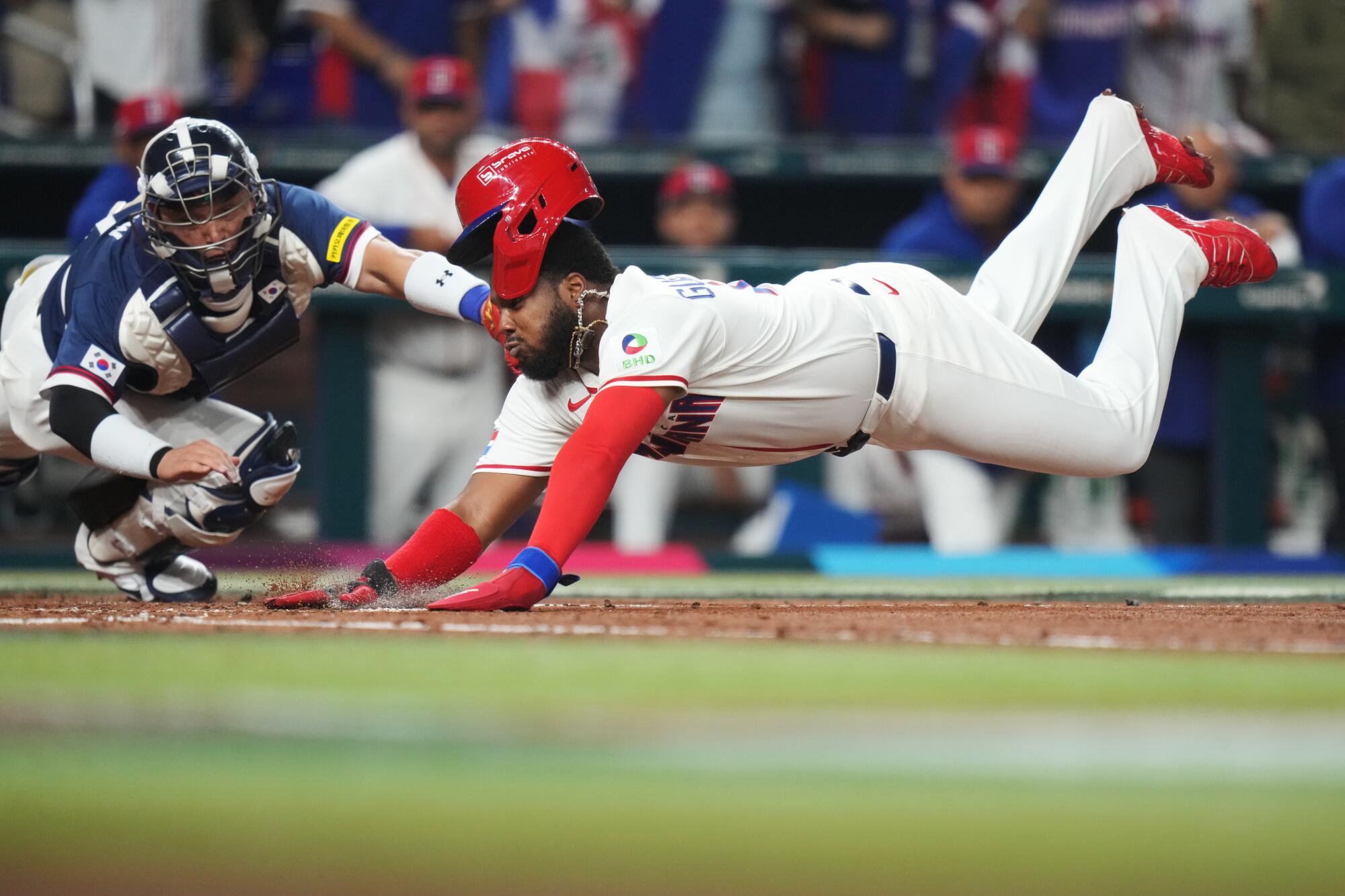 Dominican Republic's Vladimir Guerrero Jr. dives past South Korea catcher Park Dong-won to score.
