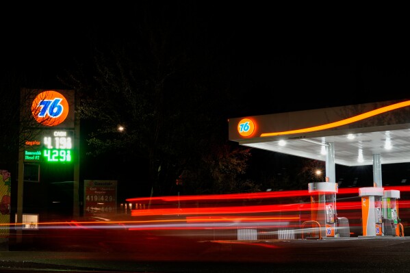 Vehicles drive past a gas station as gasoline prices are displayed March 4, 2026, in Portland, Ore. (AP Photo/Jenny Kane, File)
