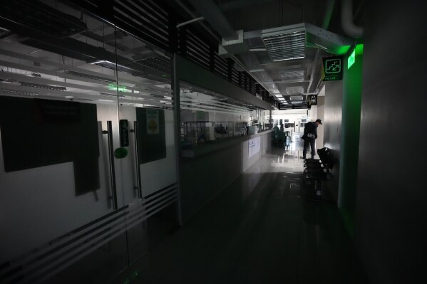 A security guard walks along offices at the Metropolitan Manila Development Authority closed due to the implementation of four-day work week as part of a government drive to conserve energy amid the continued oil price hike on Friday, March 13, 2026 in Pasig, Philippines. (AP Photo/Aaron Favilal)