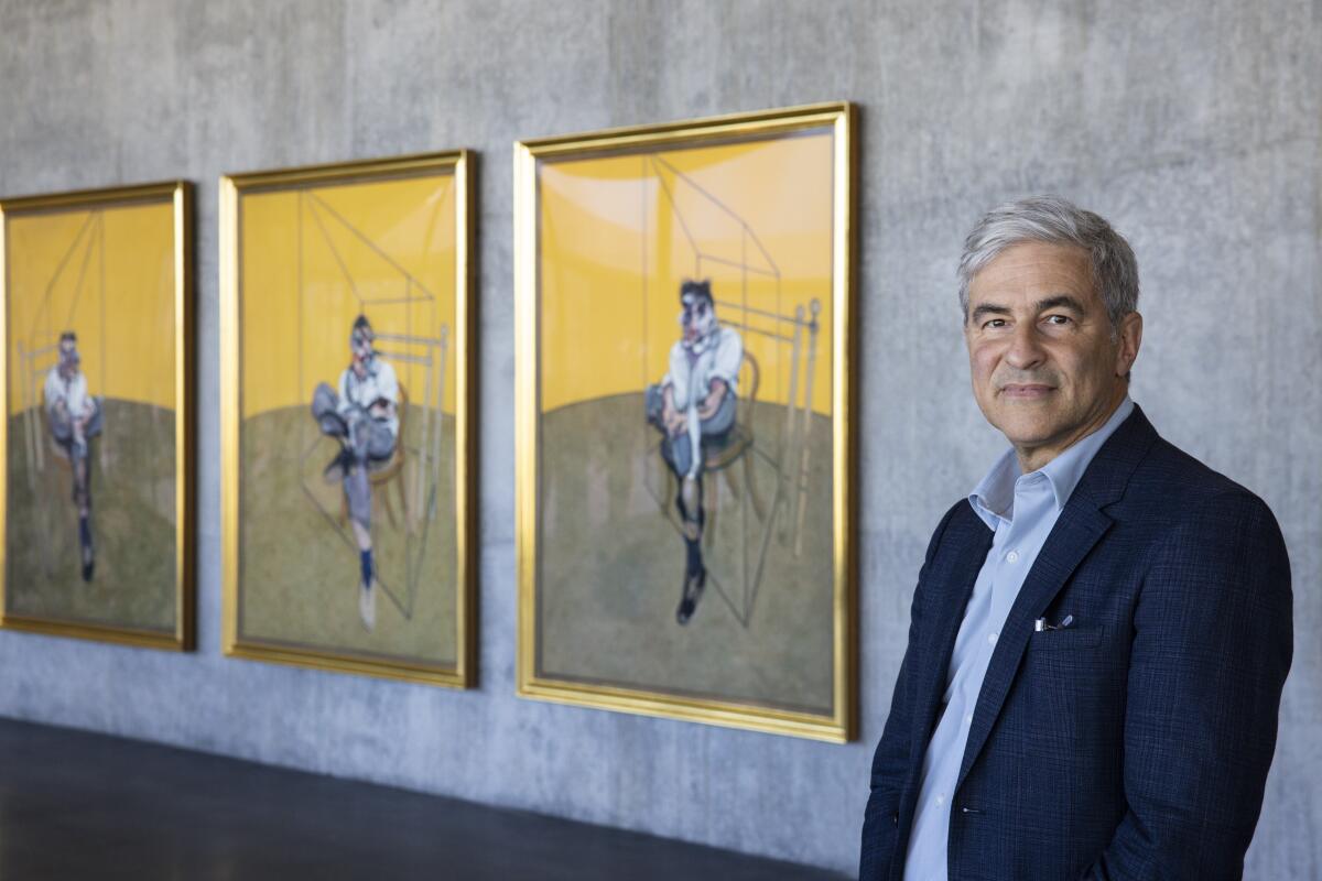 Michael Govan stands beside a triptych at LACMA.