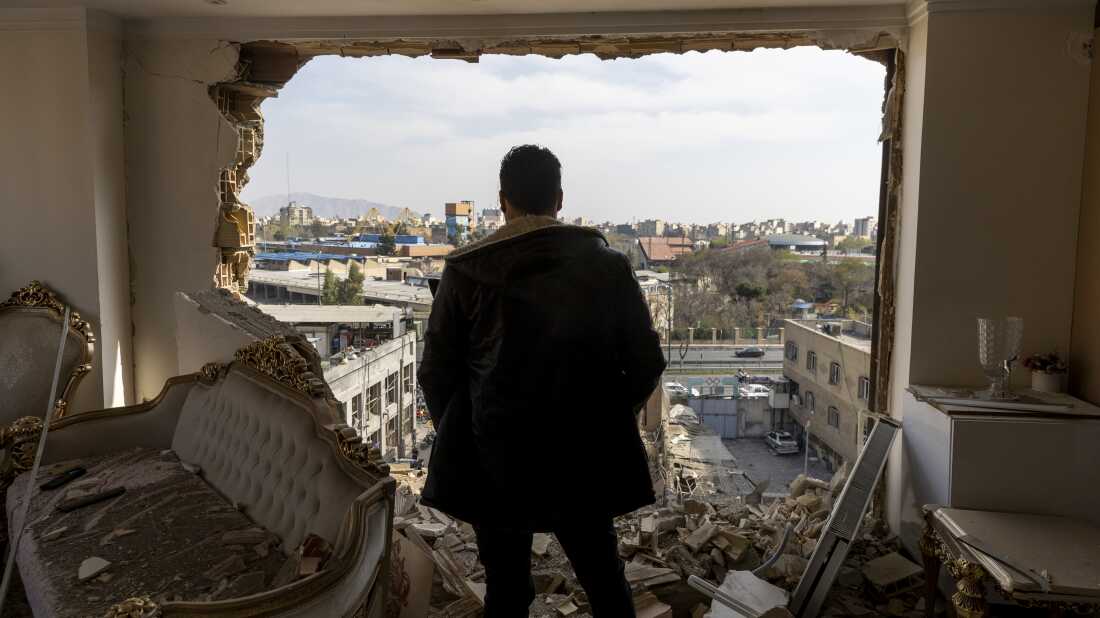 TEHRAN, IRAN - MARCH 14: A man stands in a damaged residence on March 14, 2026 at the site of buildings, including a police station, that were destroyed in an airstrike two days ago in the Khani Abad neighbourhood of Tehran, Iran. According to authorities, the police station was empty at the time of the attack but six civilians were killed. The United States and Israel have continued a campaign of air strikes in Iran after launching their joint war on the country on February 28.(Photo by Majid Saeedi/Getty Images)