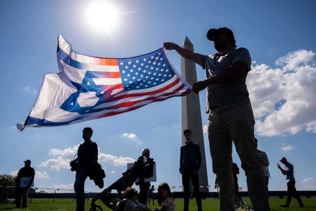 An attendee holds a U.S. and Israeli flag at an October 7th memorial rally near the Washington Monument in Washington, D.C. on Oct. 7, 2024.