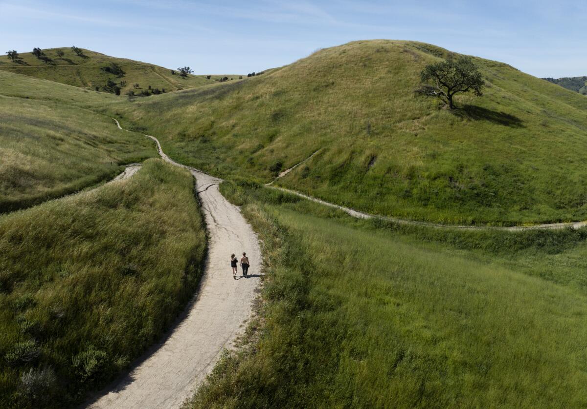Visitors hike along Victory Trailhead Loop during the heat wave on Monday in Woodland Hills.